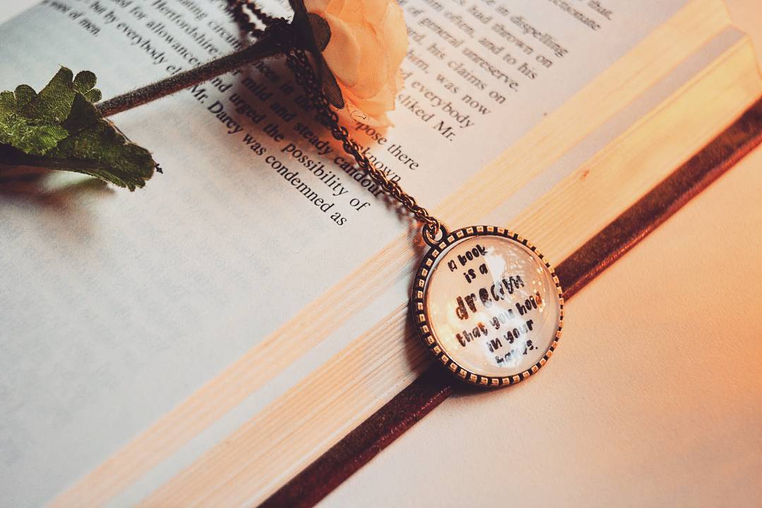 A book is a dream that you hold in your hands - Neil Gaiman Quote Pendant