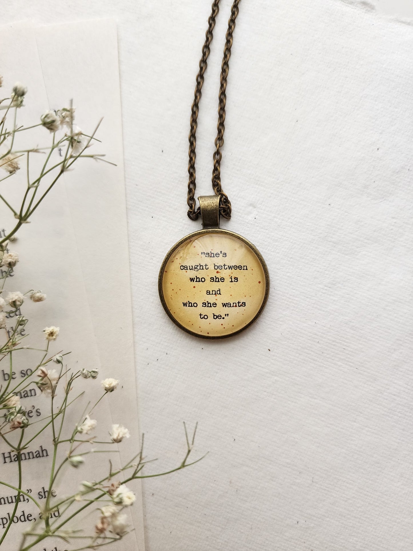 "she's caught between.." Quote Pendant