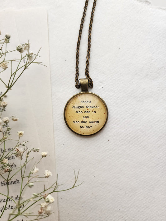 "she's caught between.." Quote Pendant